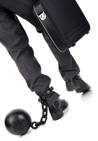 Ball and chain restraining a businessman as he walks away with a briefcase