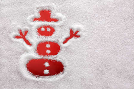 Snowman drawn in the snow with red backgroundの写真素材