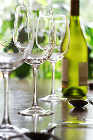 Restaurant table with silverware, white wine and wine glassesの写真素材