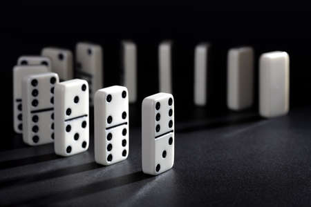 Dominoes lined up ready to fall concept for domino effect, balance and riskの写真素材