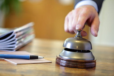 Businessman ringing a hotel reception service bell to attract attention