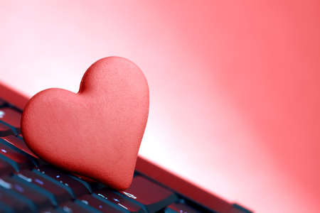 Love or online dating concept heart shape symbol on laptop keyboardの写真素材