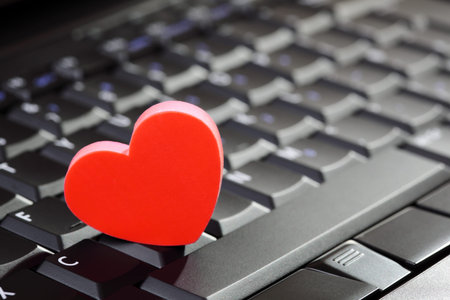 Love or online dating concept heart shape symbol on laptop keyboard