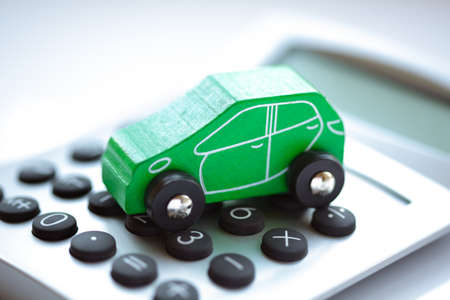 Toy car and calculator concept for buying, renting, fuel or service and repair costsの写真素材