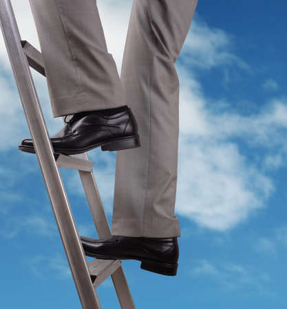 Businessman climbing the ladder of successの写真素材