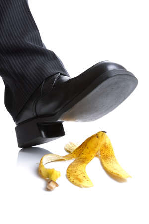 Businessman foot about to slip and fall on a banana skinの写真素材