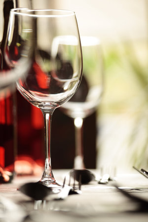 Restaurant table with silverware, wine and wine glassesの写真素材