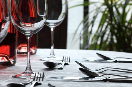 Restaurant table with silverware, wine and wine glassesの写真素材