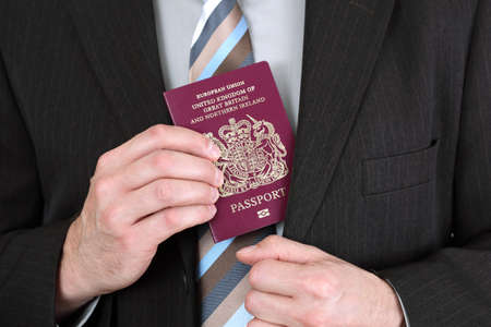 Businessman presenting a British passport at customs or check in areaの写真素材