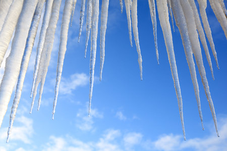 Group of melting icicles against a winter sky