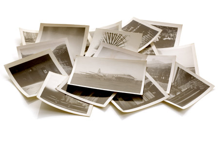 Pile of old faded photographs from the family album with soft shadows and reflections
