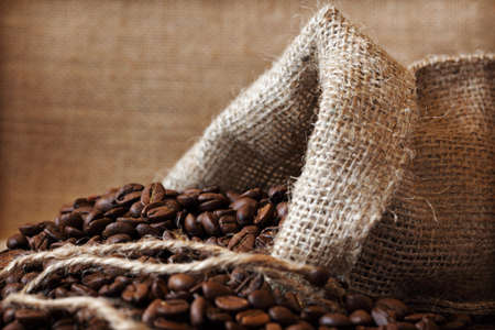 Coffee beans spilling out from a burlap sackの写真素材