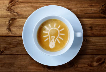 Coffee cup with light bulb idea in the froth concept for ideas, creativity and innovationの写真素材