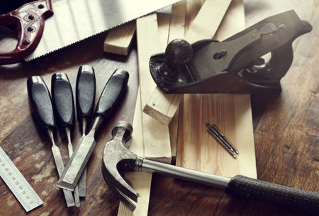 Old antique woodworking or carpentry tools on a hardwood floor concept for construction or repairing