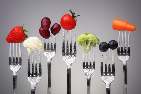 Fruit and vegetable of silver forks against a grey background concept for healthy eating, dieting...