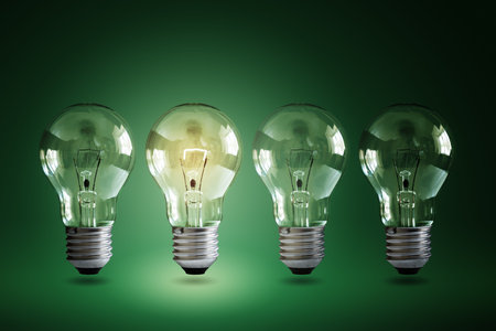 Illuminated light bulb in a row of dim ones concept for creativity, innovation and solution