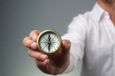 Businessman and compass showing direction concept for guidance, strategy and business orientationの写真素材