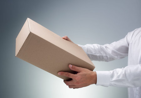 Businessman receiving or giving a cardboard box package or parcel