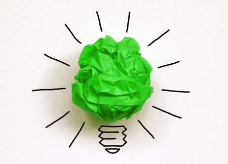 Inspiration environment concept crumpled green paper light bulb metaphor for good idea and environmental conservationの写真素材