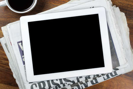 Digital tablet with blank screen on newspaper concept for internet and electronic newsの写真素材