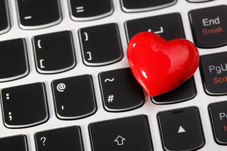 Love or online internet dating concept heart shape symbol on laptop keyboardの写真素材