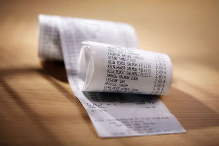 Grocery shopping list till roll printout on a wooden tableの写真素材