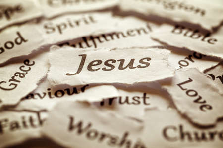 Torn paper words of religion with focus on word Jesus Torn paper words of religion with focus on word Jesus