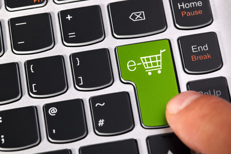 Computer keyboard key with shopping cart icon concept for e-commerce, consumerism and internet store...