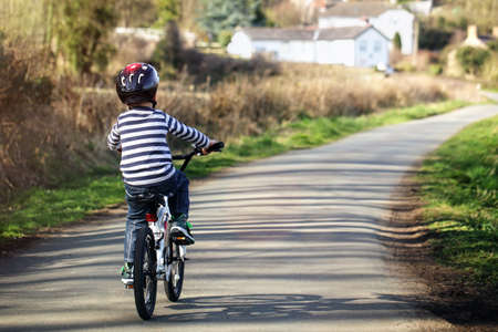 Riding a bicycle on a country road concept for healthy lifestyle, exercising and road safetyの写真素材