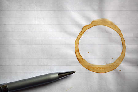 Coffee stained blank lined notepad paper background with copy space for messageの写真素材