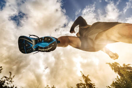 Outdoor cross-country running low angle view under runner concept for exercising, fitness and healthy lifestyleの写真素材