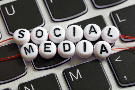Social media letter beads on laptop keyboard keyboard concept for social networking, blogging, marketing and youth cultureの写真素材