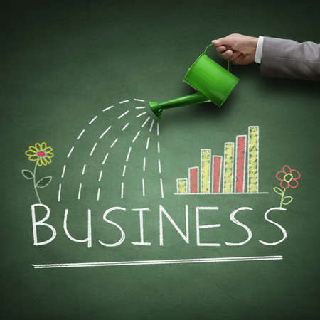 Watering can and word business drawn on a blackboard concept for business growth, investment, savings and making money Watering can and word business drawn on a blackboard concept for business growth, investment, savings and making money