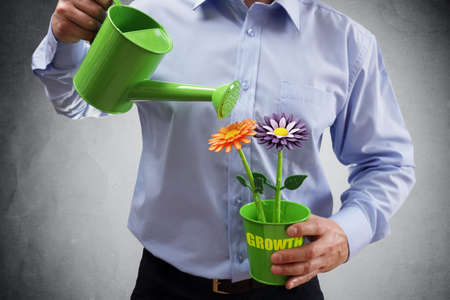Investment and growth businessman with watering can investing in business and making money conceptの写真素材