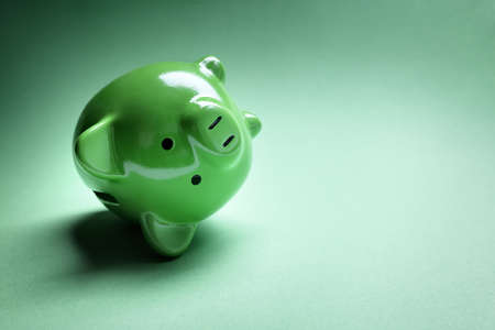 Piggy bank fallen over with financial money problems and copy spaceの写真素材