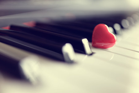Red heart on piano keyboard keys concept for love of music or romance and valentines dayの写真素材