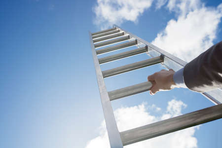 Businessman climbing the corporate ladder of successの写真素材