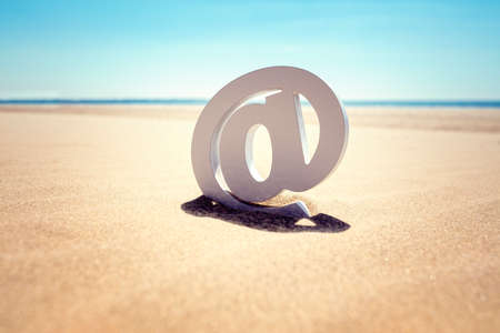 Email at symbol in the sand at the beachの写真素材