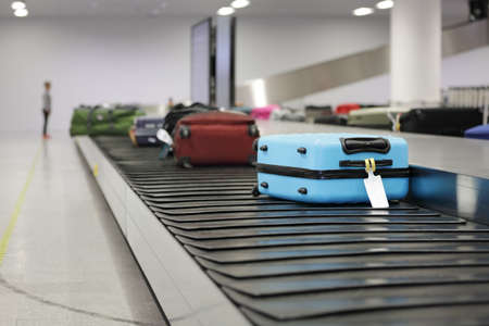 Suitcase or luggage on conveyor belt in the airport waitingの写真素材