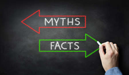 Businessman drawing Myths or Facts on blackboard conceptの写真素材