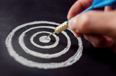 Businessman target for success holding dart on blackboard