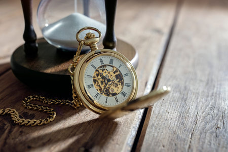 Vintage pocket watch and hour glass or sand timer, symbols of time with copy space