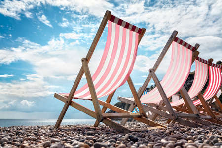 Deck chairs on the beach at the seaside on summer vacationの写真素材