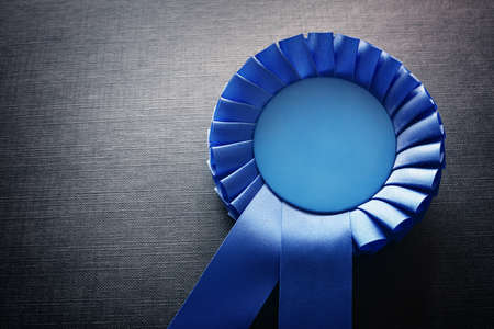 Blue award rosette with ribbons and copy space on black backgroundの写真素材