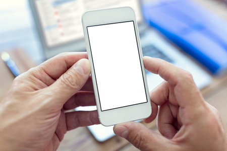 Mobile smartphone with blank white screen holding in man hand