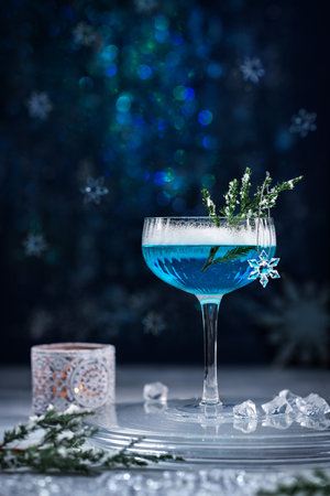 Alcoholic cocktail with gin decorated with a snowflake on a blue background. A blue alcohol drink.の写真素材