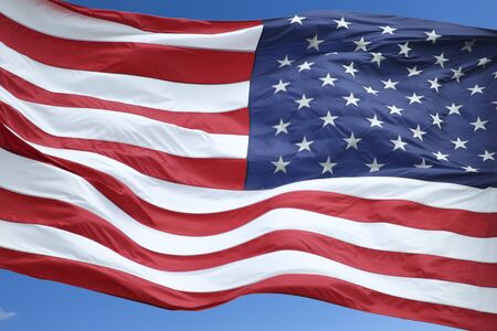 The US flag fluttering in the windの写真素材