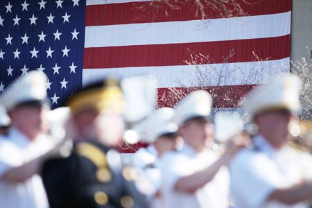 Out of focus marching band with the US flag in the background.の写真素材