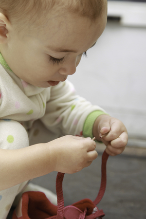 One and Half Year baby girl tying shoelaceの写真素材