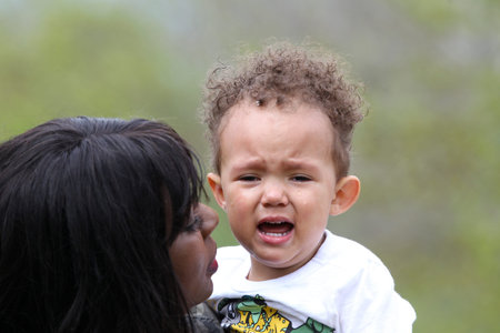 Mom tenderly held crying 2-year-old son with tears on face